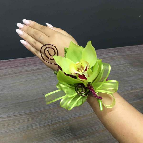 Green orchid wrist corsage with ribbon and wire accents