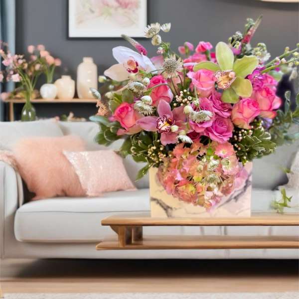Pink and peach floral arrangement in a marble-patterned box