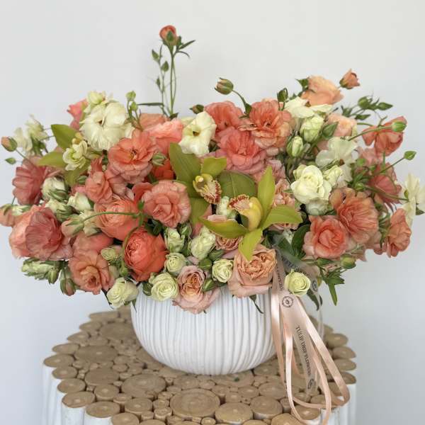 Peach and cream bouquet in a white ribbed vase