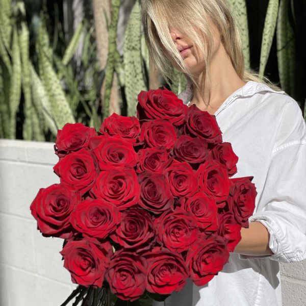 Woman holding a large bouquet of red roses