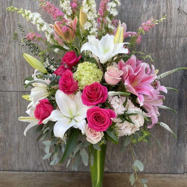 Tall bouquet of pink and white flowers in a glass vase