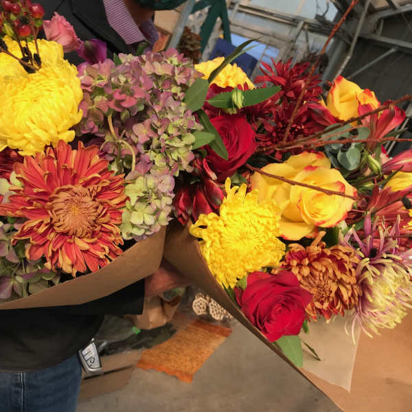 Two colorful mixed flower bouquets wrapped in brown paper