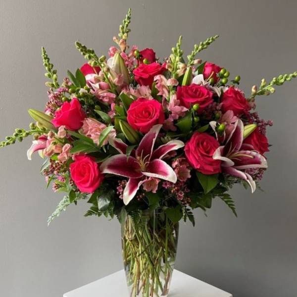 Bouquet of pink roses and lilies in a clear glass vase