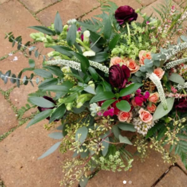 Mixed bouquet with peach roses and dark burgundy blooms