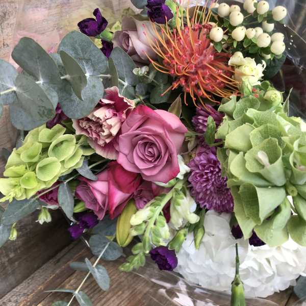 Mixed bouquet with pink roses, green hydrangea, and purple flowers