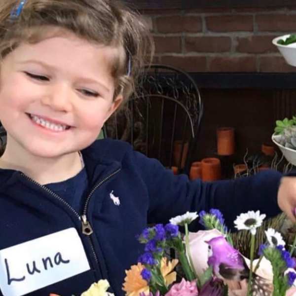 Smiling child holding a colorful mixed flower bouquet
