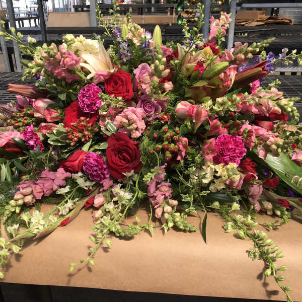 Large mixed floral arrangement with red, pink, and white blooms