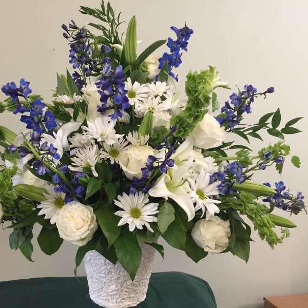 White and blue floral arrangement in a textured white vase