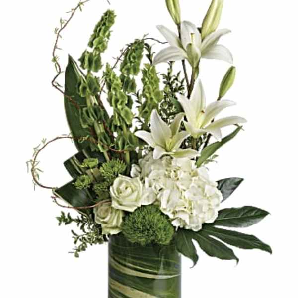 White lilies and roses arranged in a green glass vase