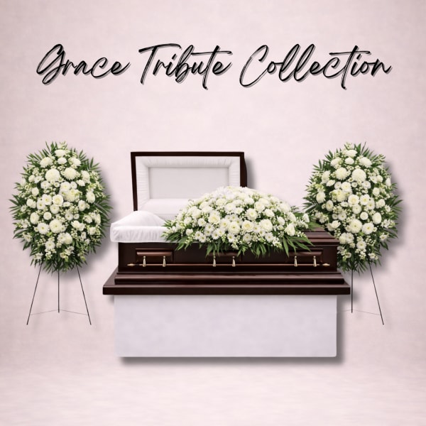 White funeral casket with white floral sprays and standing wreaths