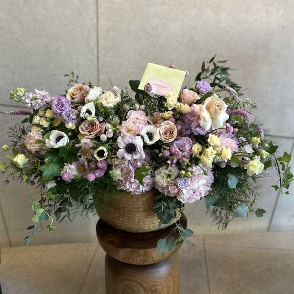 Large pastel flower arrangement in a woven basket