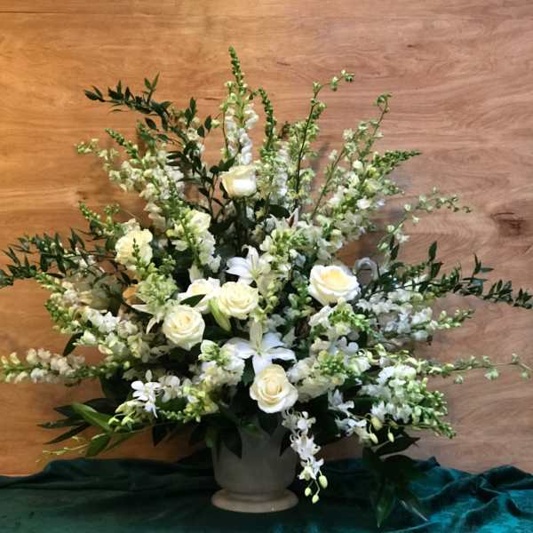 White roses and lilies arranged in a gray vase