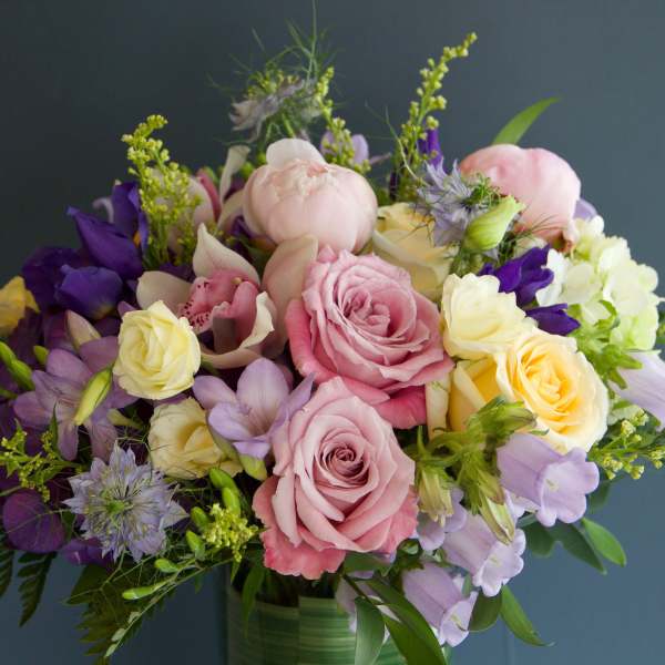 Bouquet of pink, yellow, and purple flowers in a glass vase