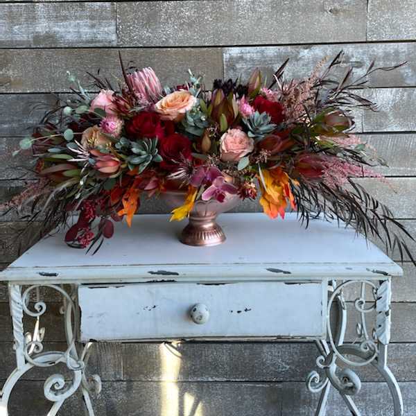 Large mixed floral arrangement in a copper vase