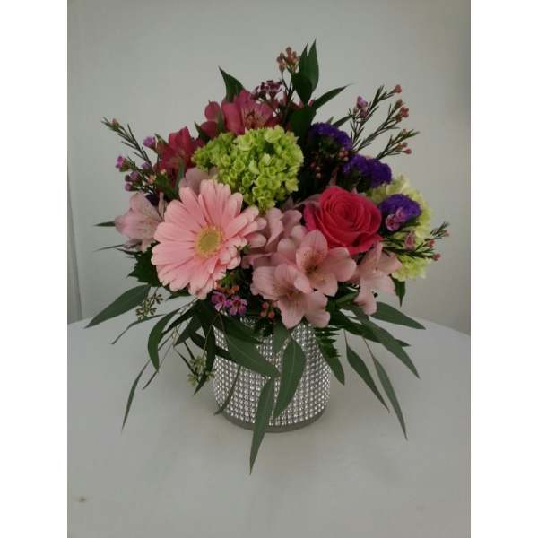 Mixed pink and purple flower arrangement in a silver vase