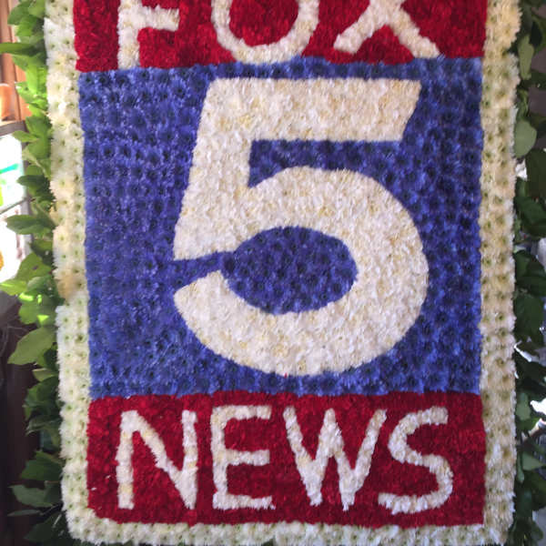 Floral sign with the FOX 5 NEWS logo in red, white, and blue