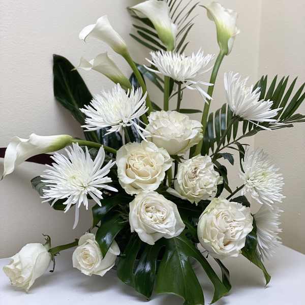White roses, calla lilies, and spider mums in a low arrangement
