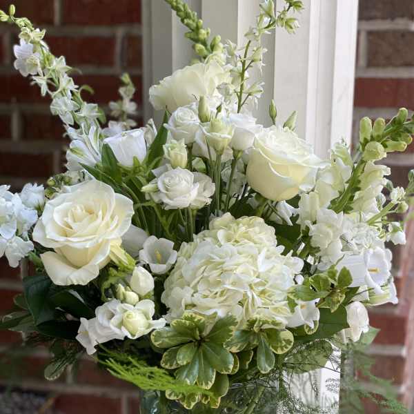 White roses and hydrangea in a clear glass vase