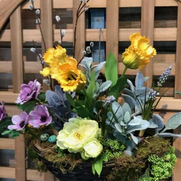 Basket arrangement with yellow and purple flowers and moss