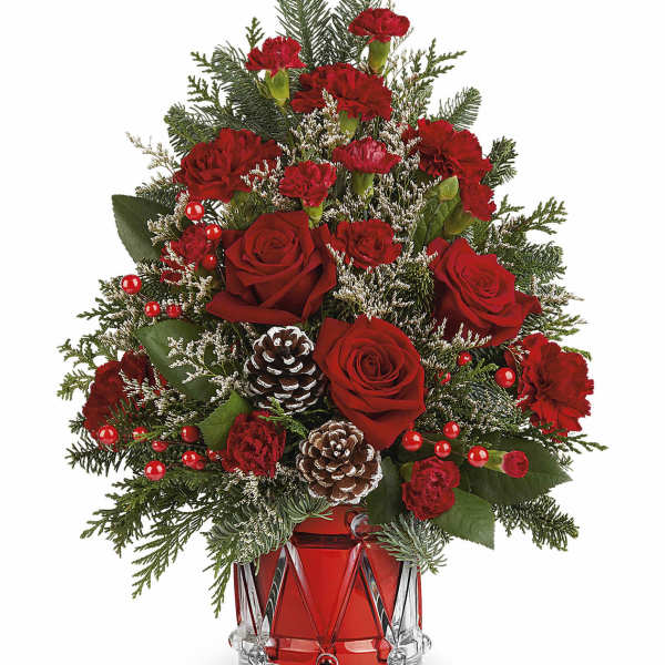 Red roses and carnations in a red glass vase with pinecones