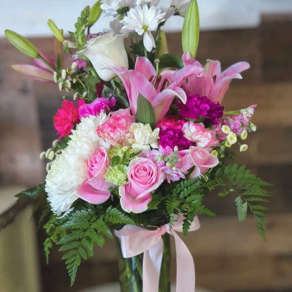 Pink and white mixed bouquet in a glass vase with a ribbon