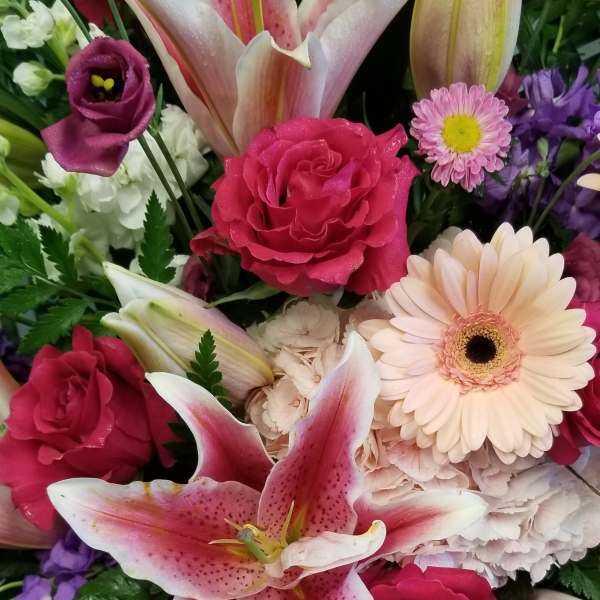 Bouquet of pink lilies, roses, and daisies in mixed colors