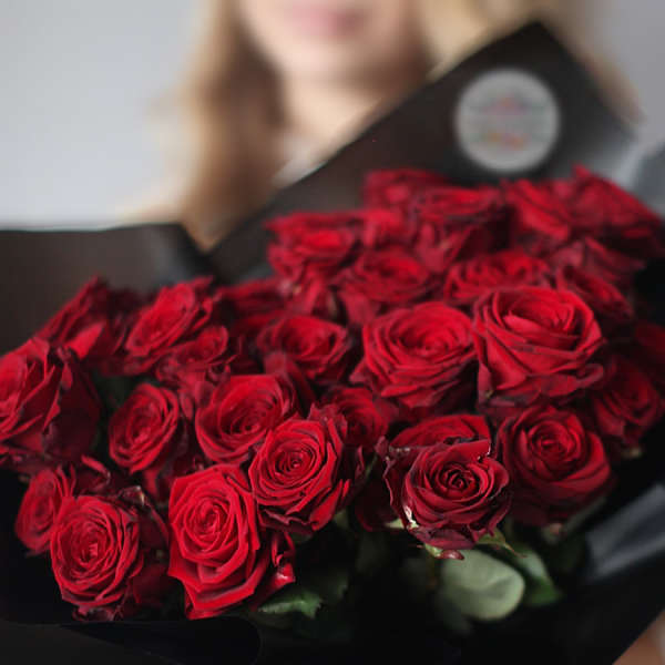 Bouquet of red roses wrapped in black paper