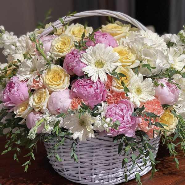 Basket of pink and yellow roses with white daisies