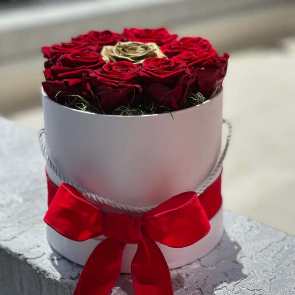 Round box of red roses with a red ribbon bow