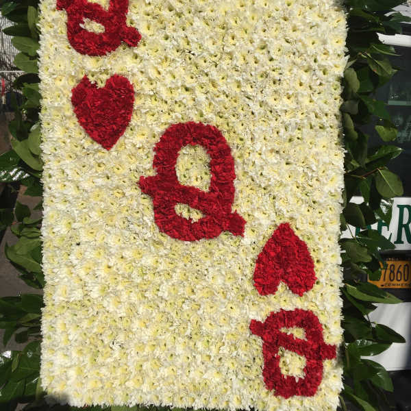 Floral tribute board with red letters on a white chrysanthemum background