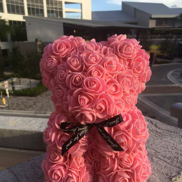 Pink rose-shaped teddy bear with a black ribbon bow