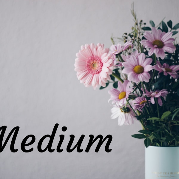 Bouquet of pink and lavender daisies in a light blue vase