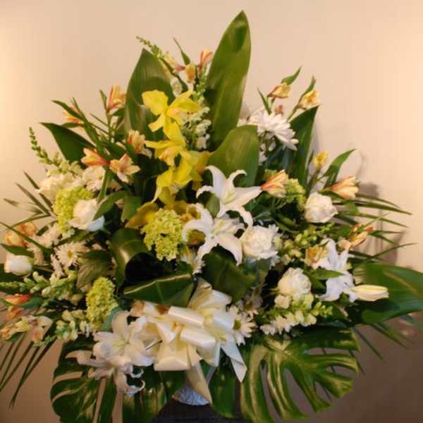 Large white and yellow floral arrangement in a vase