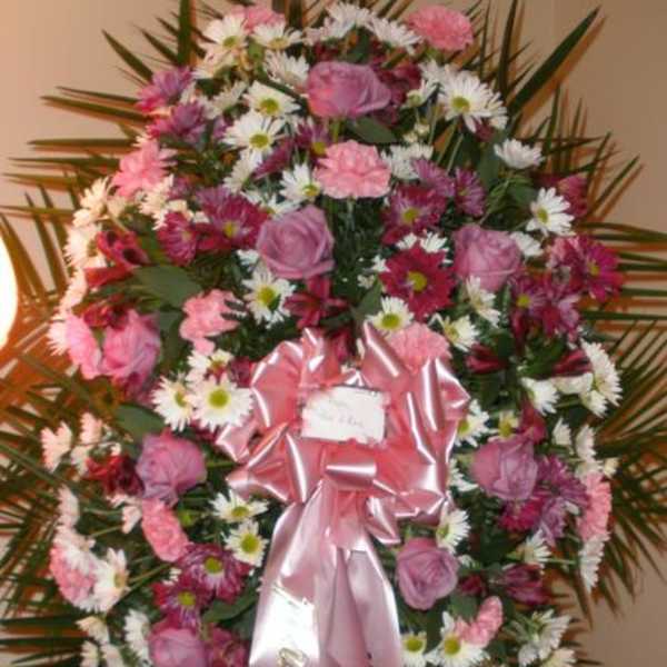 Pink and white floral standing spray with a pink ribbon
