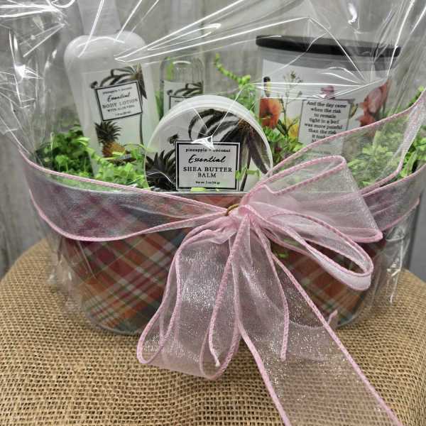 Gift basket with body lotion, shea butter balm, and a pink ribbon