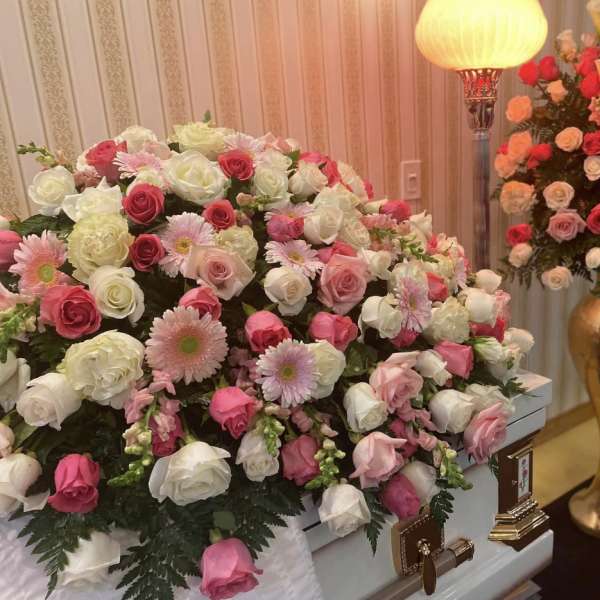 Large pink and white floral casket spray with roses and daisies