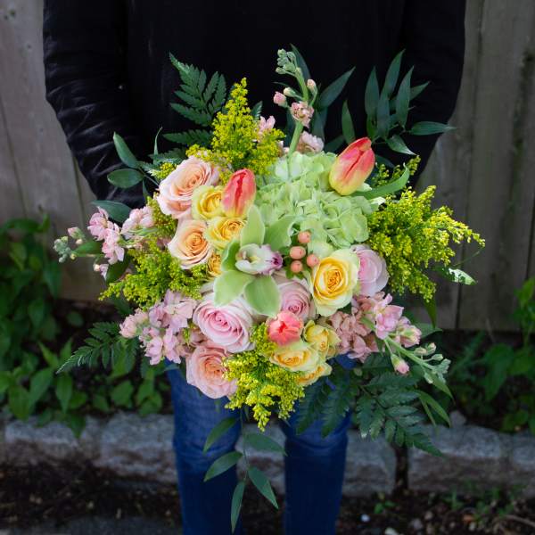 Handheld bouquet of pastel roses, tulips, and green hydrangea