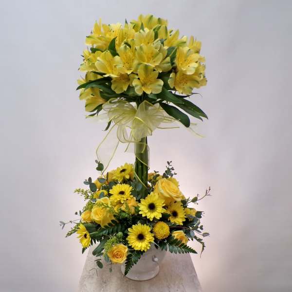 Yellow floral arrangement with roses and daisies in a white vase