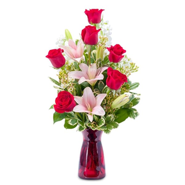 Red roses and pink lilies in a red glass vase