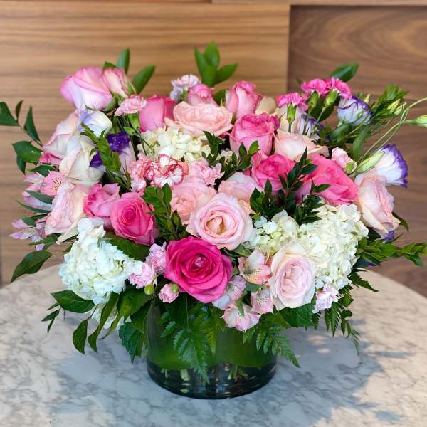 Pink and white rose arrangement in a glass vase