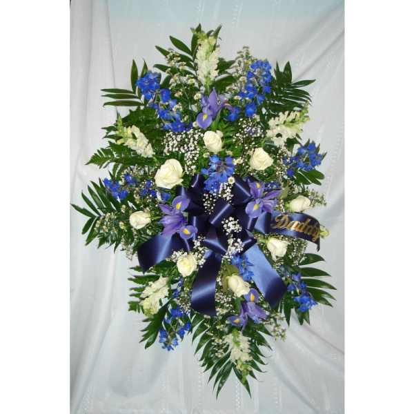 Large floral spray with white roses, blue and purple flowers, and a navy ribbon