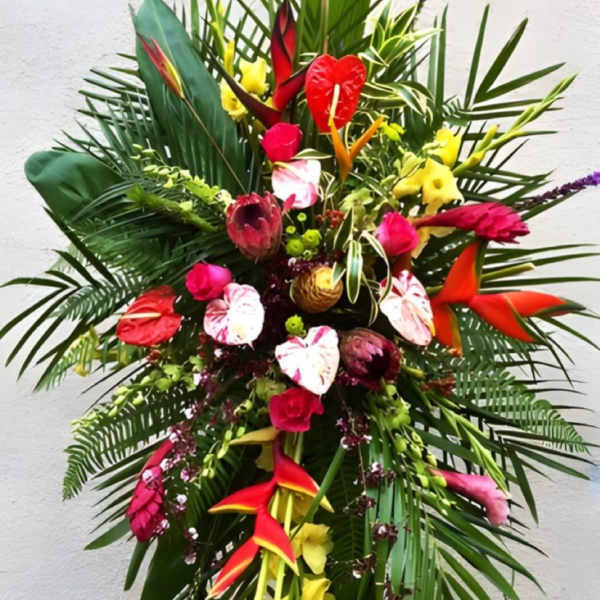 Tall tropical flower arrangement with red, pink, and yellow blooms