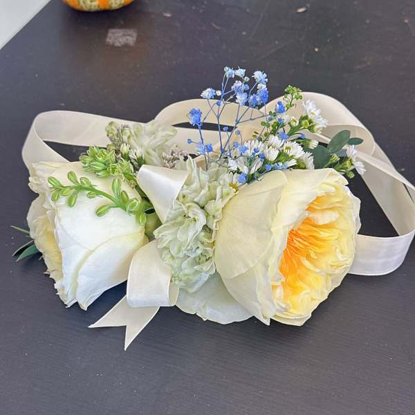 Cream rose bouquet with blue filler flowers and satin ribbon