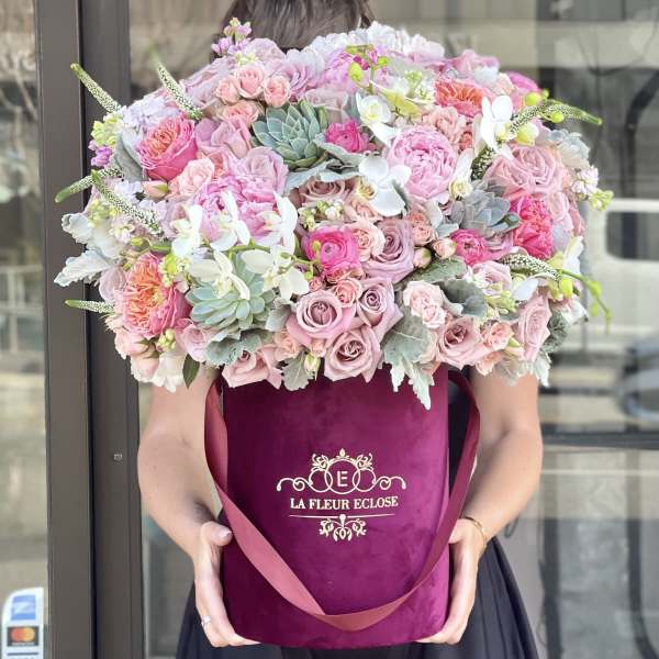 Large pink bouquet in a magenta hatbox with roses and orchids