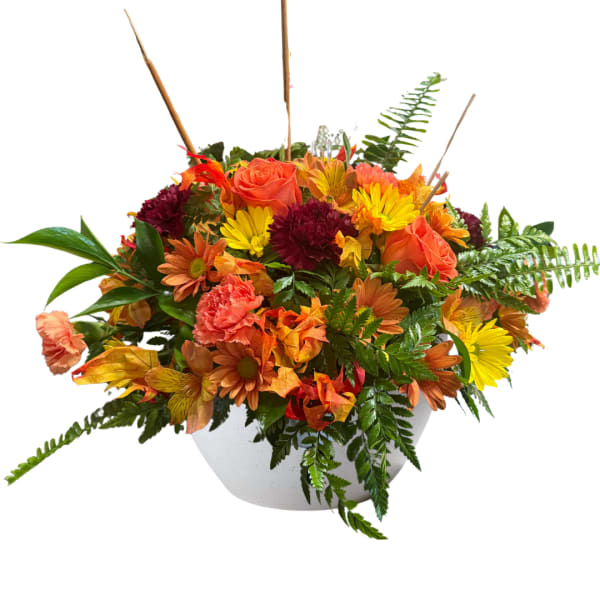 Autumn bouquet of orange roses and yellow daisies in a white bowl vase