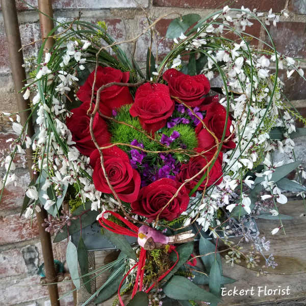 Heart-shaped bouquet of red roses with white blossoms and purple accents