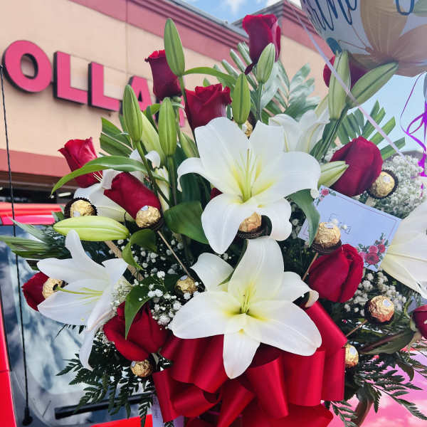 Bouquet of white lilies and red roses with a red ribbon