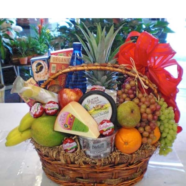 Gift basket with fruit, cheese, and packaged snacks tied with a red bow