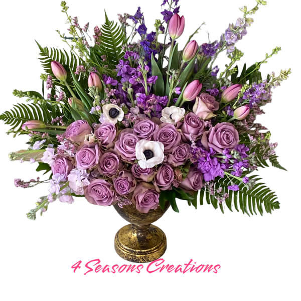 Lavender rose arrangement with pink tulips and purple flowers in a gold vase