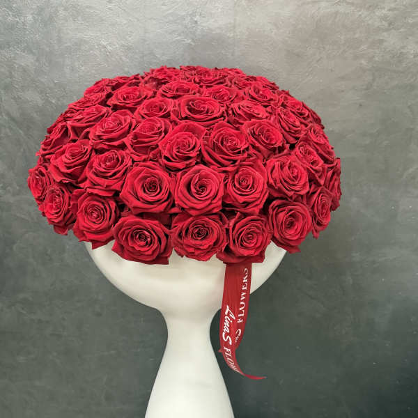 Large dome of red roses in a white vase with a red ribbon